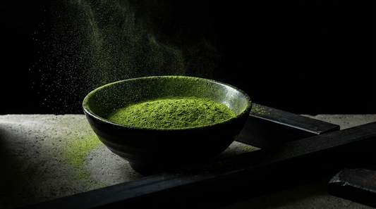 Bowl of vivid green Uji matcha powder on a dark industrial surface