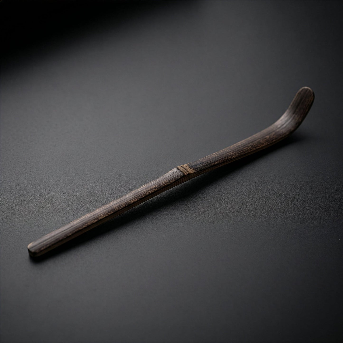 Dark bamboo chashaku matcha scoop on black background 